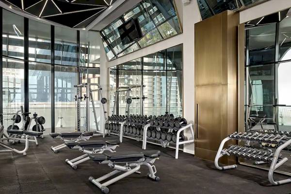 Fitnesscenter im Grand Hyatt Abu Dhabi Hotel mit vielen Geräten und großen Fenstern.