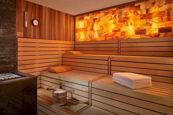 Innenansicht der Sauna im Grand Hyatt Abu Dhabi Hotel mit Holzbänken und orangefarbenen Wänden.