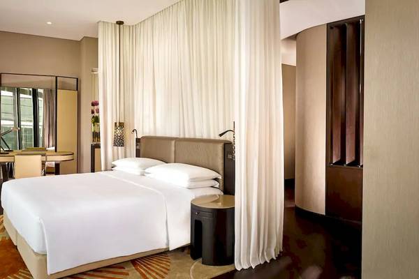 Schlafzimmer im Grand Hyatt Abu Dhabi Hotel mit einem Bett, weißen Vorhängen und modernen Möbeln.