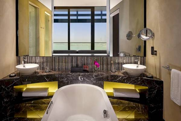 Badezimmer im Grand Hyatt Abu Dhabi Hotel & Residences Emirates Pearl mit Badewanne, Waschbecken und Ausblick auf den Hafen