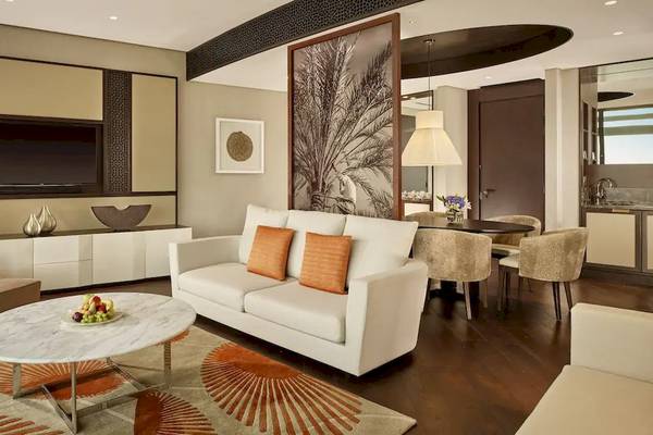 Das Wohnzimmer im Grand Hyatt Abu Dhabi Hotel mit einer weißen Couch, Tisch und Fernseher.
