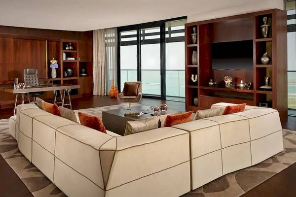 Modernes Wohnzimmer im Grand Hyatt Abu Dhabi Hotel mit großen Sofas, Esstisch und Meerblick.