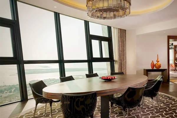 Inneneinrichtung des Grand Hyatt Abu Dhabi Hotel mit Esstisch, Stühlen und Blick auf die Stadt.