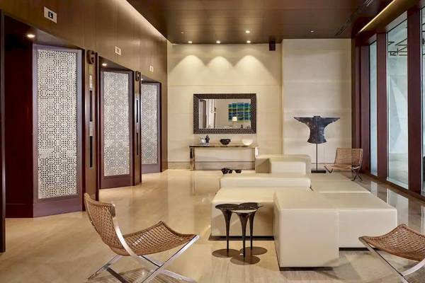 Inneneinrichtung des Grand Hyatt Abu Dhabi Hotel mit weißen Möbeln, dunklen Holztüren und großen Glasfenstern.