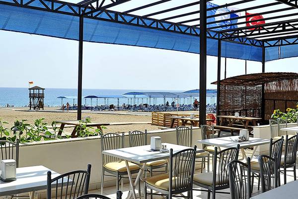 Terrasse des Cenger Beach Resort & Spa mit Blick auf den Strand und Sonnenblumen.