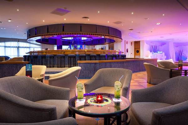 Loungebereich des Paradisus by Melia Gran Canaria mit einer zentralen Bar und runden Tischen.