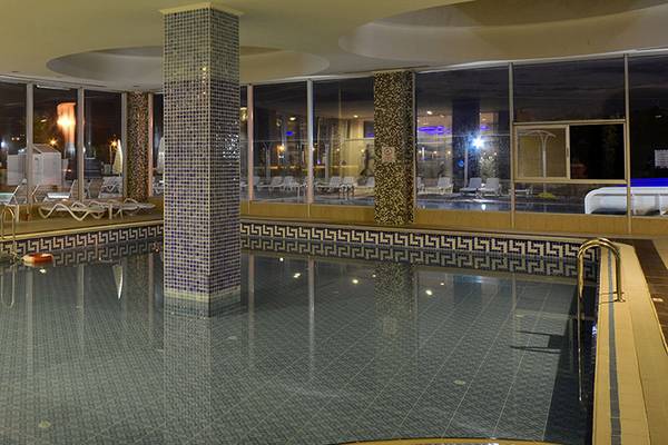 Innenbereich des Cenger Beach Resort & Spa mit Swimmingpool und Loungebereich.