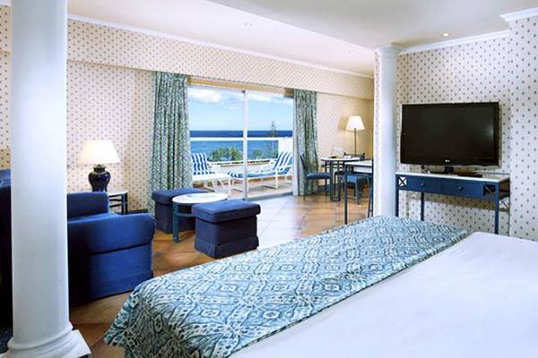 Hotelzimmer im Paradisus by Melia Gran Canaria mit Meerblick, Fernseher und blauen Möbeln.