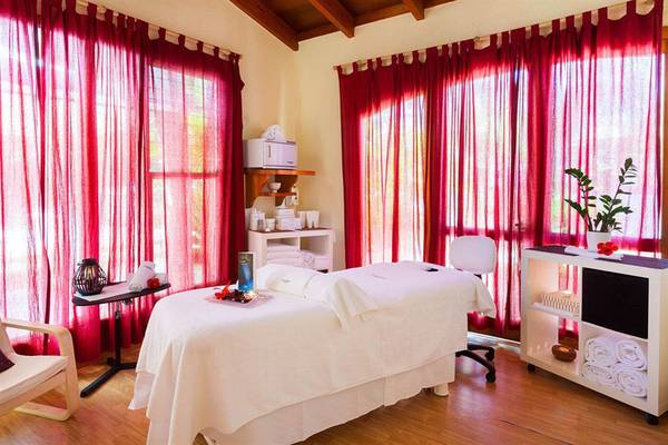 Innenansicht eines Massageraums im Paradisus by Melia Gran Canaria mit roten Vorhängen und Behandlungsliege.
