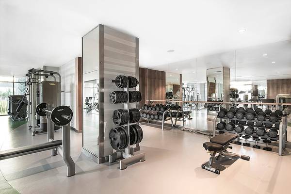 Fitnesscenter im Titanic Deluxe Lara Hotel mit verschiedenen Trainingsgeräten und Spiegeln.