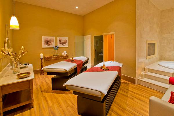 Spa-Behandlungsraum im Titanic Deluxe Lara Hotel mit zwei Massagetischen, einem Whirlpool und einem Sofa.