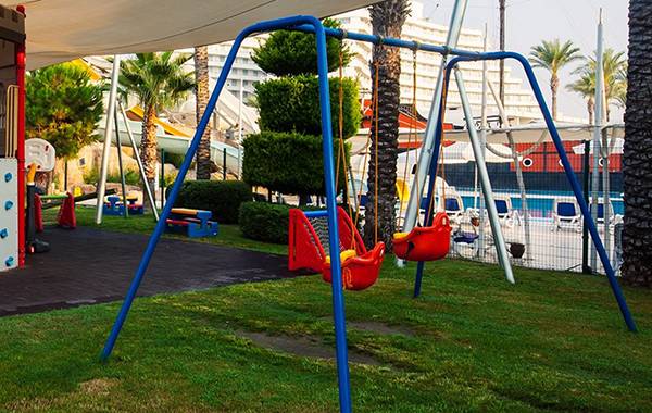Spielplatz im Freilichtbereich des Titanic Deluxe Lara Hotels mit Rutsche und Schaukeln
