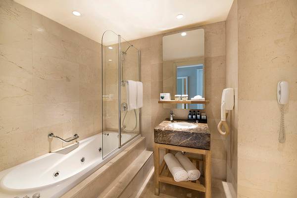 Hotel Titanic Deluxe Lara Badezimmer mit Badewanne, Dusche, Waschbecken und Föhn.