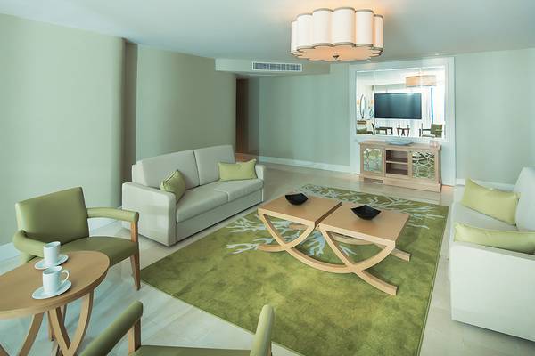 Wohnzimmer im Titanic Deluxe Lara Hotel mit zwei Sofas, Couchtisch und Fernseher.