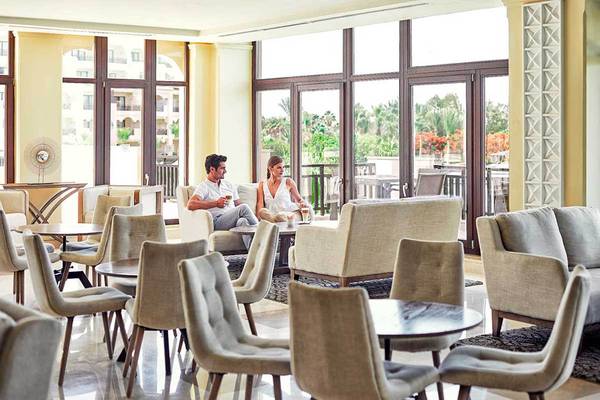 Ein Paar entspannt in der Lounge des Steigenberger ALDAU Beach Hotels mit Blick auf eine Terrasse.