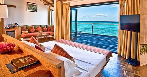 Interieur des Reethi Beach Resorts mit Blick auf das Meer von einem Schlafzimmer und Badezimmer.