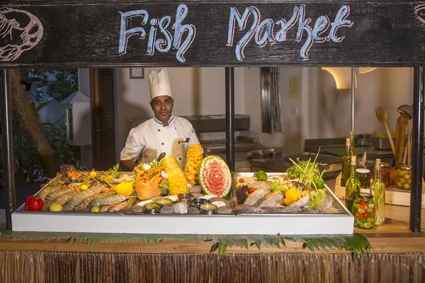 Ein Koch steht hinter einem Fischmarktstand im Reethi Beach Resort.