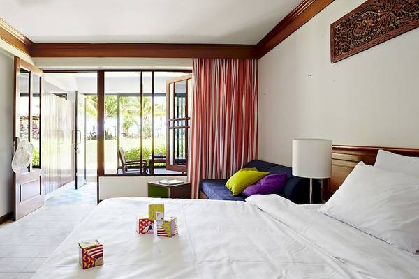 Hotelzimmer im Sunwing Kamala Beach mit Bett, Sofa und Fenstern.