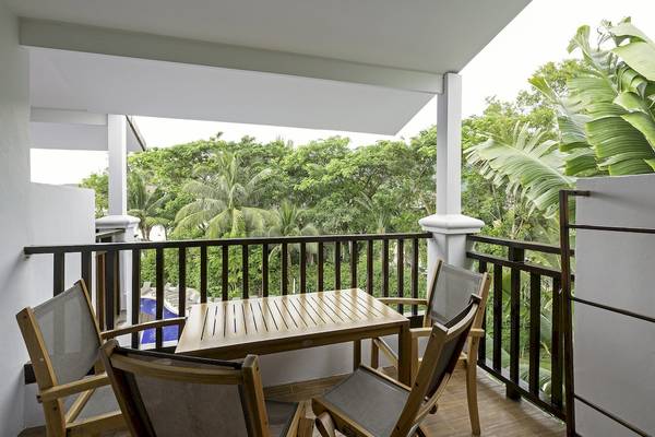 Hotelbalkon mit Tisch und Stühlen, Ausblick auf Wald und Swimmingpool