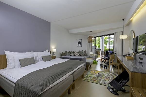 Hotelzimmer im Sunwing Kamala Beach mit Doppelbett, Wohnzimmerbereich und Terrasse.