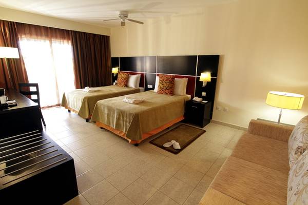 Doppelzimmer mit Sofa im Valentin Varadero El Patriarca Hotel, zwei Betten und ein Sofa.