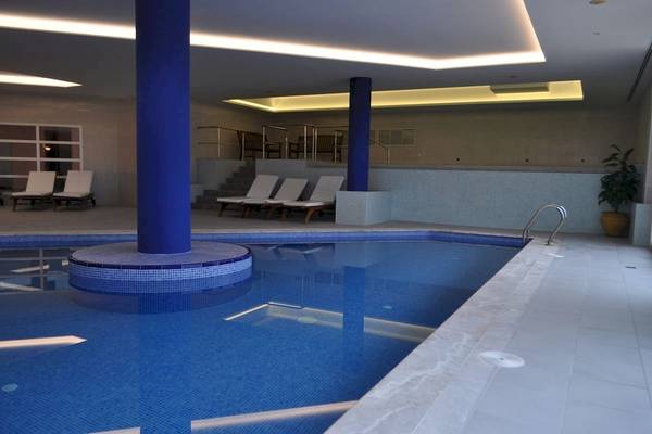Innenpool des Bordoy Don Antonio Hotels mit Loungebereich und blauen Säulen.