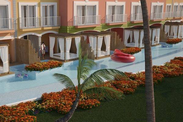 Außenbereich des Grand Palladium Bavaro Suites Resort & Spa mit mehreren Gebäuden, einem Pool und Palmen.