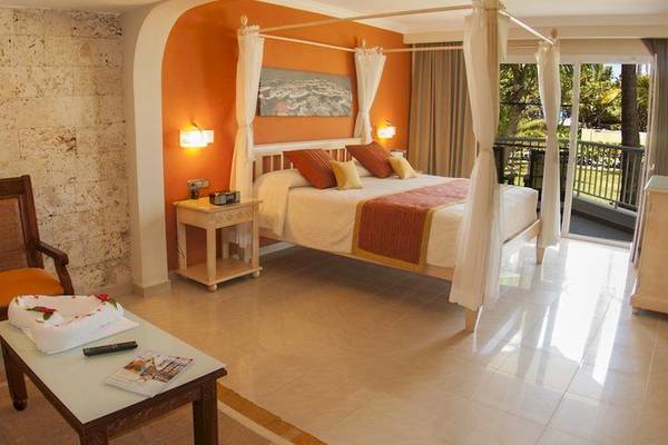Schlafzimmer im Grand Palladium Bavaro Suites Resort & Spa mit Bett, Nachttisch und Balkon