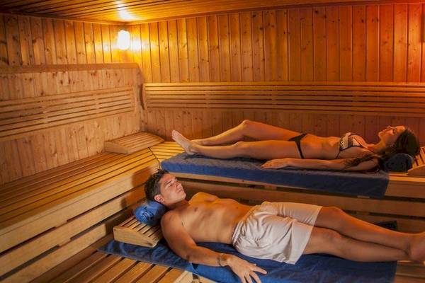 Zwei Personen entspannen sich in einer Holzsauna des Grand Palladium Bavaro Suites Resort & Spa