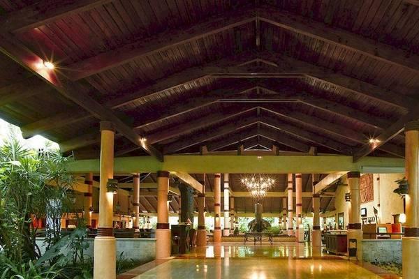 Lobby des Grand Palladium Bavaro Suites Resort & Spa mit Holzdecke und Pflanzen.