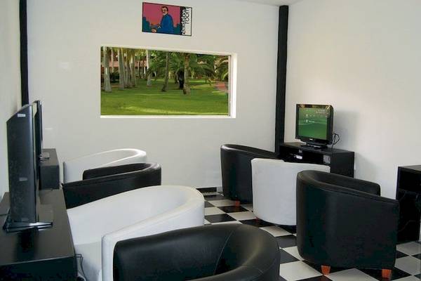 Spielzimmer im Grand Palladium Bavaro Suites Resort & Spa mit Fernsehern und Stühlen.