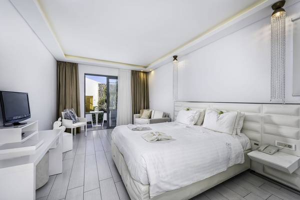 Ein elegantes Schlafzimmer im Diamond Deluxe Hotel mit einem großen Bett, weißem Dekor und moderner Einrichtung.