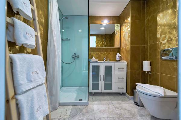 Badezimmer im Diamond Deluxe Hotel mit goldenen Wänden und weißen Möbeln.