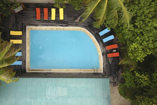 Luftaufnahme des Reethi Beach Resorts Schwimmbad mit Lounge-Stühlen und Palmen