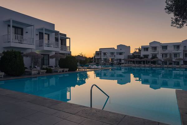 Der Pool des Diamond Deluxe Hotels am Abend mit umliegenden Gebäuden und Sonnenuntergang.