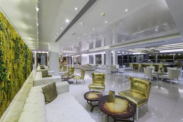 Lobby des Diamond Deluxe Hotels mit weißen Möbeln und goldenen Stühlen.