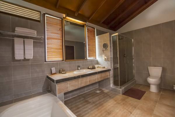 Badezimmer im Reethi Beach Resort mit Badewanne, Dusche, Toilette und Waschbecken.