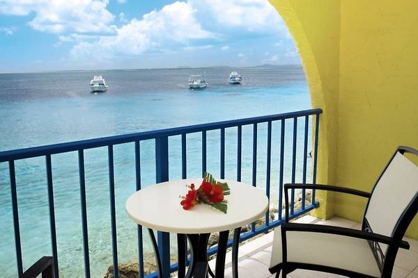 Balkon des Divi Flamingo Beach Resorts mit Blick auf das Meer und Boote in der Ferne.