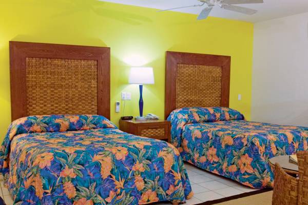 Zwei Betten mit blauen und orangefarbenen Blumenbezügen in einem Hotelzimmer im Divi Flamingo Beach Resort and Casino.