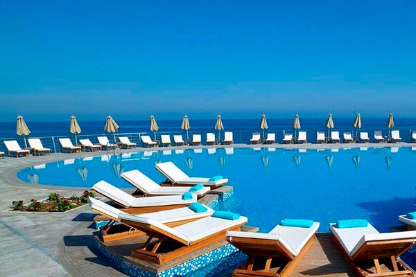 Infinity-Pool mit vielen Liegestühlen und Sonnenschirmen am Royal Blue Resort