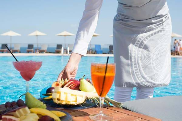 Service am Pool des Royal Blue Resorts mit Obst und Cocktails.