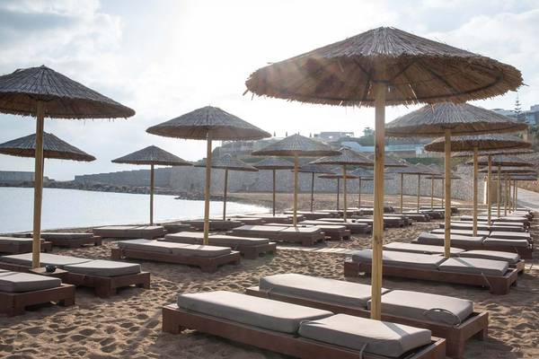 Strandszene mit Loungesesseln und Sonnenschirmen im Royal Blue Resort.