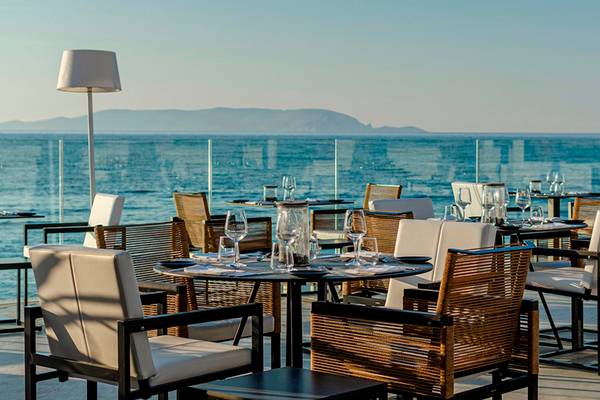 Terrasse des Knossos Beach Bungalows Suites Resort & Spa mit Blick auf das Meer.