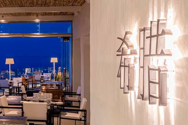 Innenansicht des Restaurants im Knossos Beach Bungalows Suites Resort & Spa mit Blick auf den Ozean