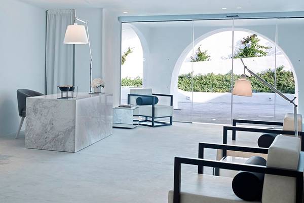 Innenbereich des Knossos Beach Bungalows Suites Resort & Spa mit weißem Marmortisch, schwarzen Vasen und modernen Möbeln.