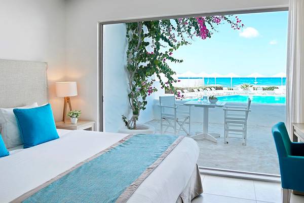 Schlafzimmer im Knossos Beach Bungalows Suites Resort & Spa mit Blick auf den Pool
