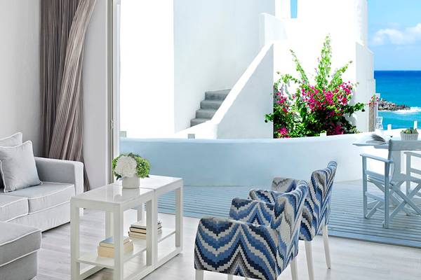 Innenansicht des Wohnzimmers im Knossos Beach Bungalows Suites Resort & Spa mit Blick auf das Meer.