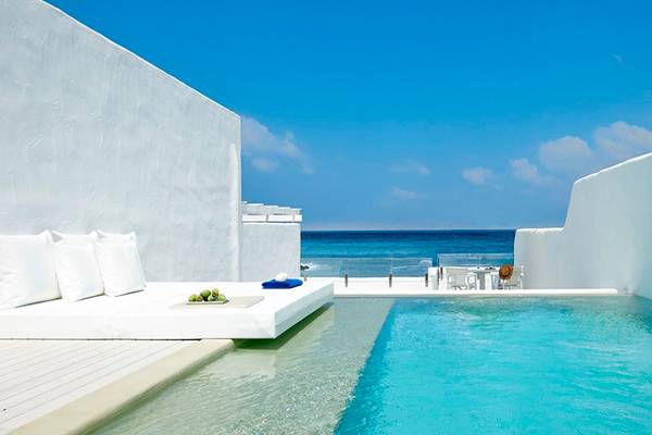 Außenbereich des Knossos Beach Bungalows Suites Resort & Spa mit Pool und Meerblick.