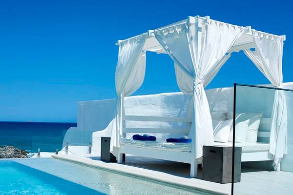 Terrasse mit Bett am Pool im Knossos Beach Bungalows Suites Resort & Spa