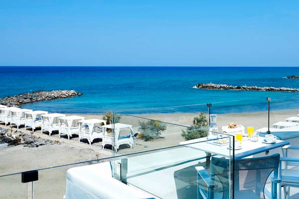 Aussicht auf den Strand mit Strandliegen im Knossos Beach Bungalows Suites Resort & Spa.